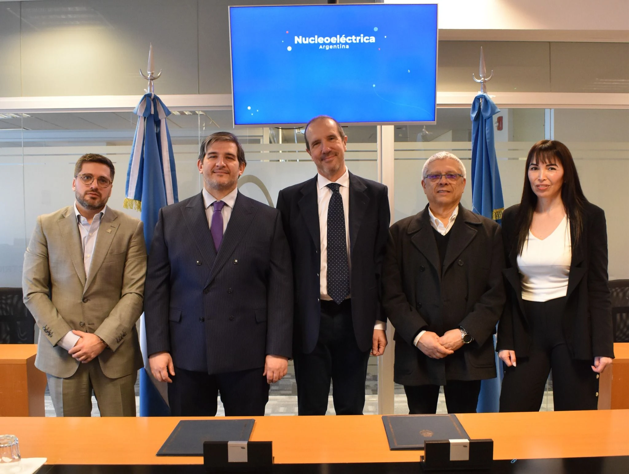 Representantes y equipo de Nucleoeléctrica Argentina y la AATN posan tras la firma del convenio.