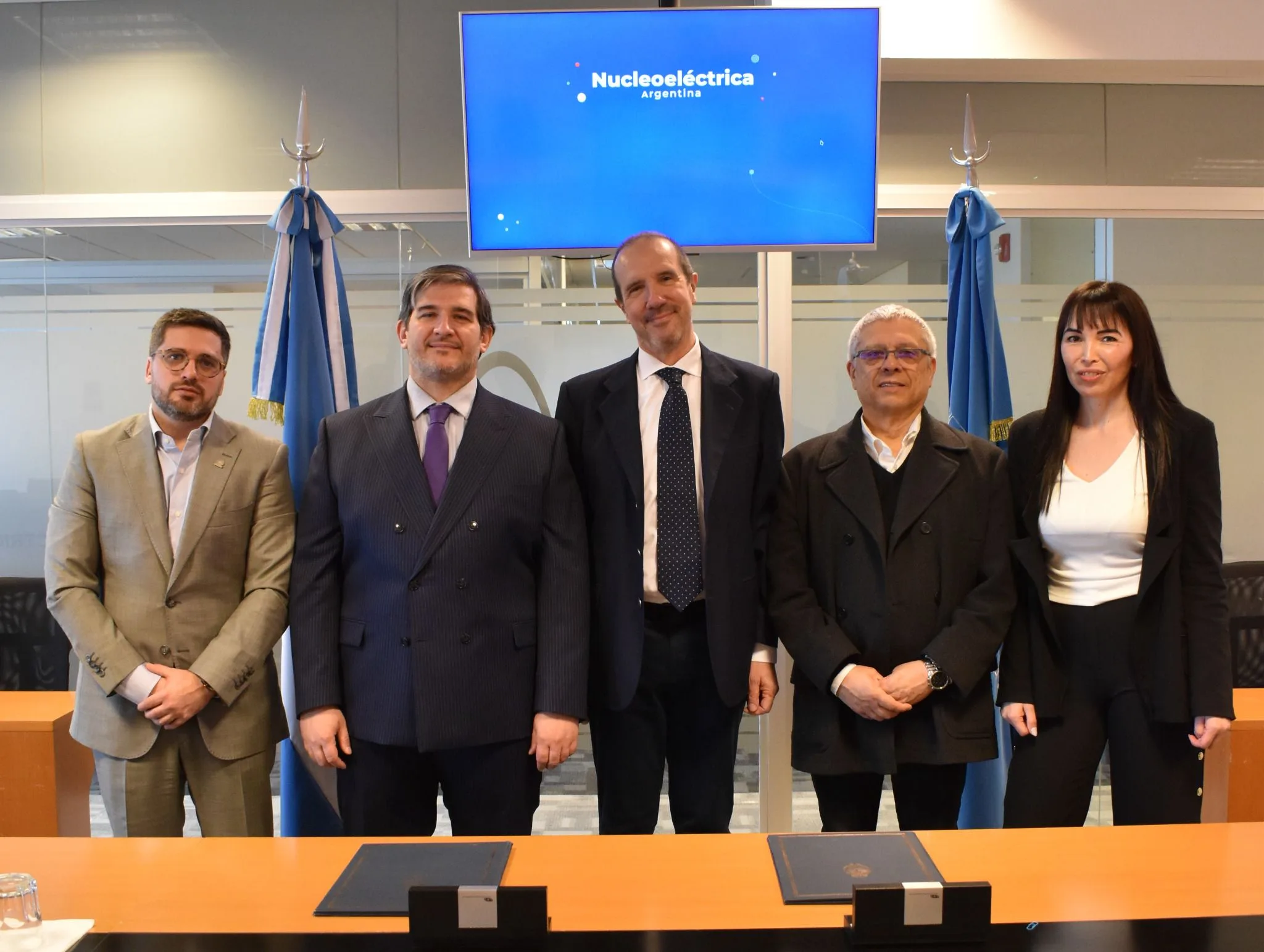 Representantes y equipo de Nucleoeléctrica Argentina y la AATN posan tras la firma del convenio.